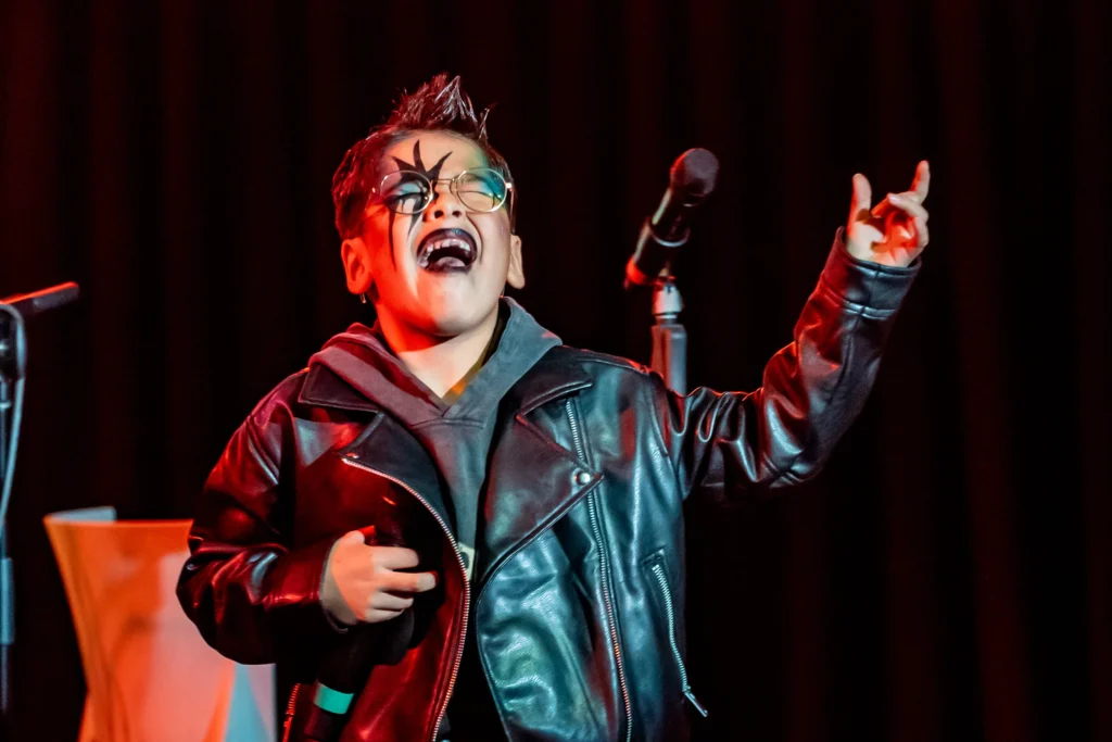 Young performer singing a rock and roll costume for a halloween party